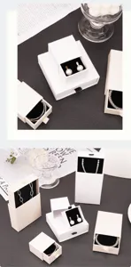 Detail showing various sizes of white drawer jewelry boxes with black velvet lining