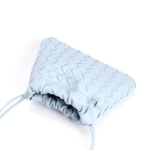Detail view of the light blue woven leather pouch bag showing exquisite craftsmanship.