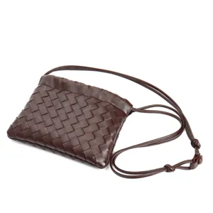 Dark brown woven leather crossbody bag with thin strap, chic dumpling pouch design for women.