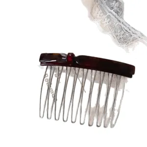 Acetate hair comb with sweet bow design, tortoiseshell finish and metal tines for styling bangs.