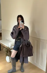 Detailed view of a dark brown large suede tote bag, styled with a casual trench coat outfit.