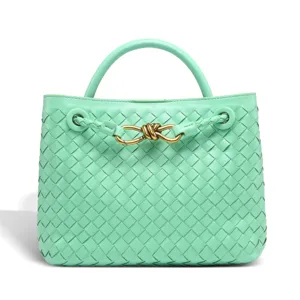 Mint green woven leather handbag detail showing delicate artisanal craftsmanship and metal knot.