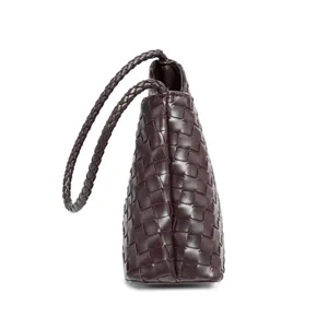 Detailed view of the dark brown woven leather shoulder bag showcasing artisanal braided texture.