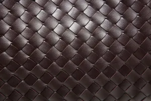 Woven leather texture detail view of trendy handmade shoulder bag, premium fashion accessory.