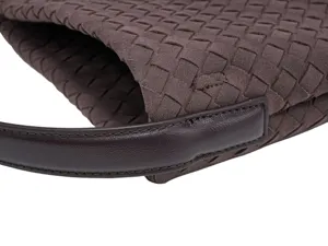 Brown woven suede leather handbag detail close up view showing texture and fine stitching craft.