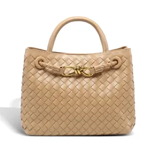 Detailed view of women's woven leather handbag with elegant knot metal hardware.