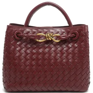 Luxury dark red woven leather handbag with metallic knot detail for women. Elegant tote.
