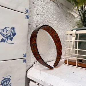 Vista dettagliata di un cerchietto tartarugato vintage, elegante accessorio per capelli da donna.