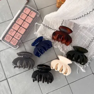 Detailaufnahme im Flat-Lay-Stil von kleinen Harz-Haarklammern in verschiedenen Farben.