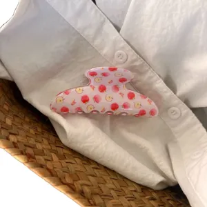 Jolie pince à cheveux rose avec motif pomme, accessoire de coiffure style français chic.