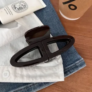 Elegante molletta per capelli marrone a doppio semicerchio, accessorio chic e minimalista.