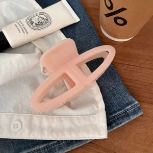 Morsetto per capelli geometrico rosa minimalista vista dettaglio, elegante accessorio quotidiano.