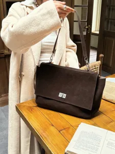 Brown suede tote bag with flap and metal lock, classic shoulder bag detail shot.