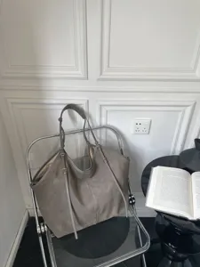 Grey suede tote bag detail, slouchy casual design with long shoulder straps and metal hardware.