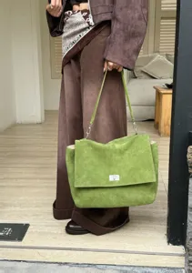 Green suede tote bag with flap and metal lock closure, perfect for daily commute and casual use.