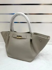 Gray leather tote bag with unique wing design and metal buckle. Elegant womens crossbody bag.