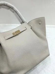 Grey leather tote bag for women, stylish top handle crossbody bag with metallic clasp closure.