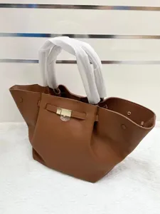 Brown leather handbag for women, elegant winged tote bag with top handles and stylish buckle.