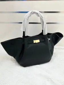 Black leather winged handbag with top handle and metal closure, stylish daily tote bag for women.