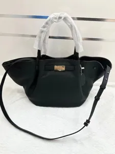 Black leather winged handbag, stylish top-handle crossbody bag with adjustable strap for women.