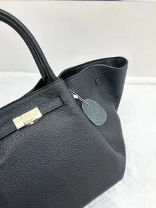 Elegant black genuine leather women tote bag with top handles and stylish winged design details.