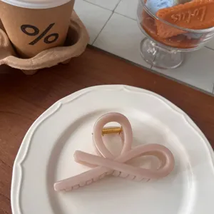 Elegant bow hair claw clip for women, stylish acrylic shark clip for daily hairstyles.