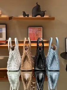 Chic leather laser-cut tote bag featuring detailed perforated design and elegant top handles.