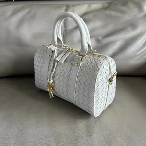 Detailed view of the vintage woven leather Boston handbag with top handles and stylish knot.