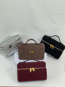 Detail view of woven cosmetic vanity bags in multiple colors featuring metal zippers.