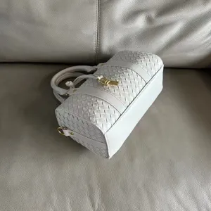 White woven leather Boston bag detail showing intricate craftsmanship and knot hardware.