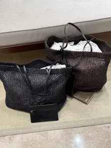 Detail view of large woven tote bag with minimalist design, comfortable shoulder straps and pouch.