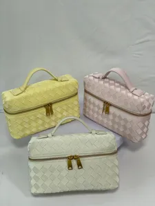 Woven vanity cosmetic bag set with top handle and gold zipper in stylish glossy design.