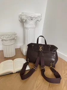 Retro dark brown leather backpack detail shot with metal hardware and suede texture.