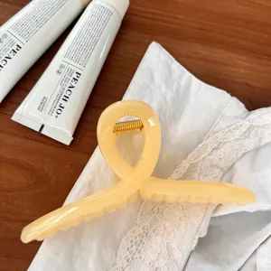 Elegante Haarklammer in Geleefarbe, stilvolles gedrehtes Design für tägliches Haarstyling.