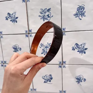Dettaglio di un cerchietto per capelli marrone largo, design lucido, elegante accessorio.