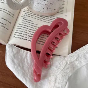 Detalle de pinza de pelo de corazón rosa, accesorio de estilo dulce para uso diario.