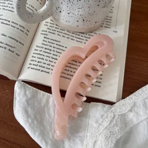 Primer plano detallado de una encantadora pinza de pelo rosa con forma de corazón muy elegante.