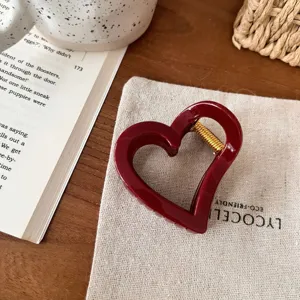 Dunkelrote herzförmige Haarklammer mit goldener Feder, süßes Haaraccessoire Detailansicht.