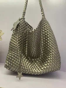 Detailed view of the metallic silver woven bucket shoulder bag featuring a stylish star charm.
