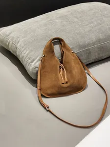 Detailed view of the stylish brown suede triangular shoulder handbag with fine strap.