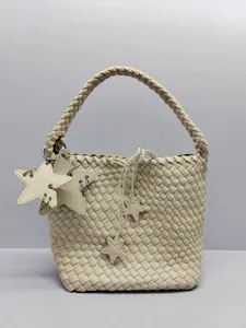 Detailed view of the chic woven bucket bag featuring unique star charms and braided handle.