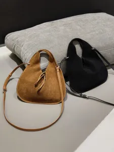 Close-up of suede triangle dumpling bags showcasing soft leather texture and straps.