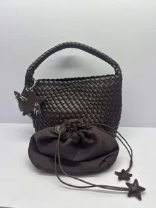 Brown woven bucket bag with matching drawstring pouch and star charms for casual use.