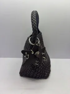 Dark brown woven leather shoulder bag detail, featuring unique star charm and metal rings.