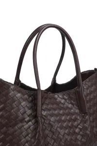 Brown woven leather tote bag detail close-up showcasing artisanal intrecciato craftsmanship.
