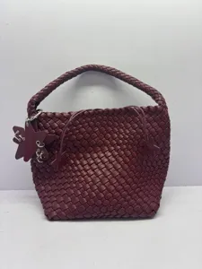 Burgundy woven leather shoulder bag detail showing intricate braided handle and star charm design.