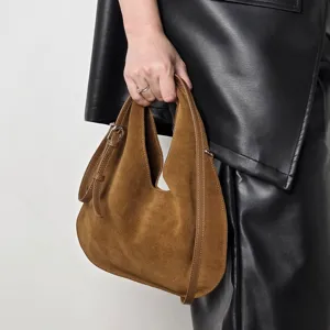 Brown suede hobo bag detail shot, showing soft leather texture and stylish metal buckle design.