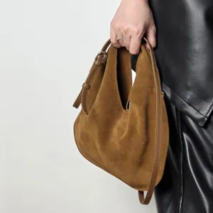 Brown suede hobo bag for women, stylish leather triangular dumpling handbag with strap.