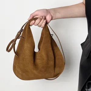 Brown suede hobo shoulder bag detail, soft genuine leather texture handle closeup view.