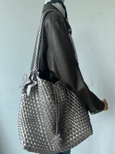 Detailed view of metallic silver woven shoulder bag with star charms and stylish design.